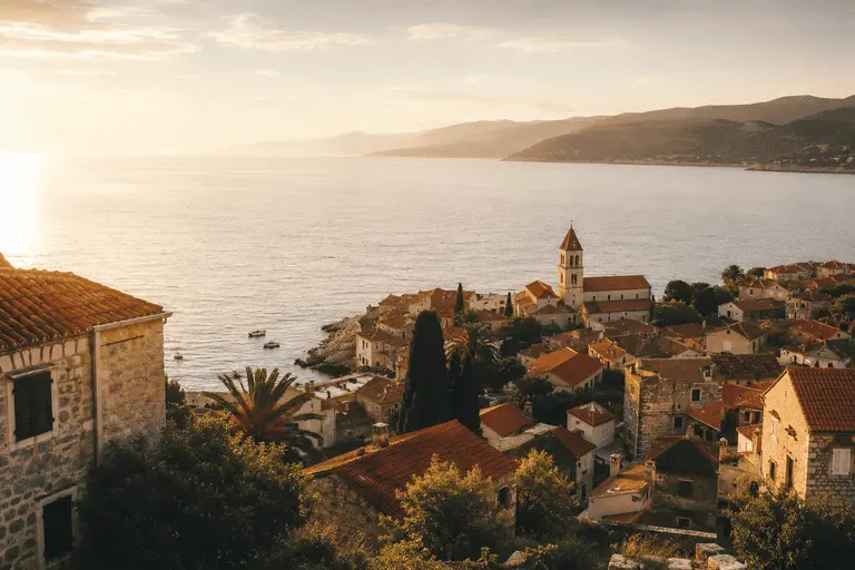 Sunlit Mediterranean coastal town with terracotta rooftops